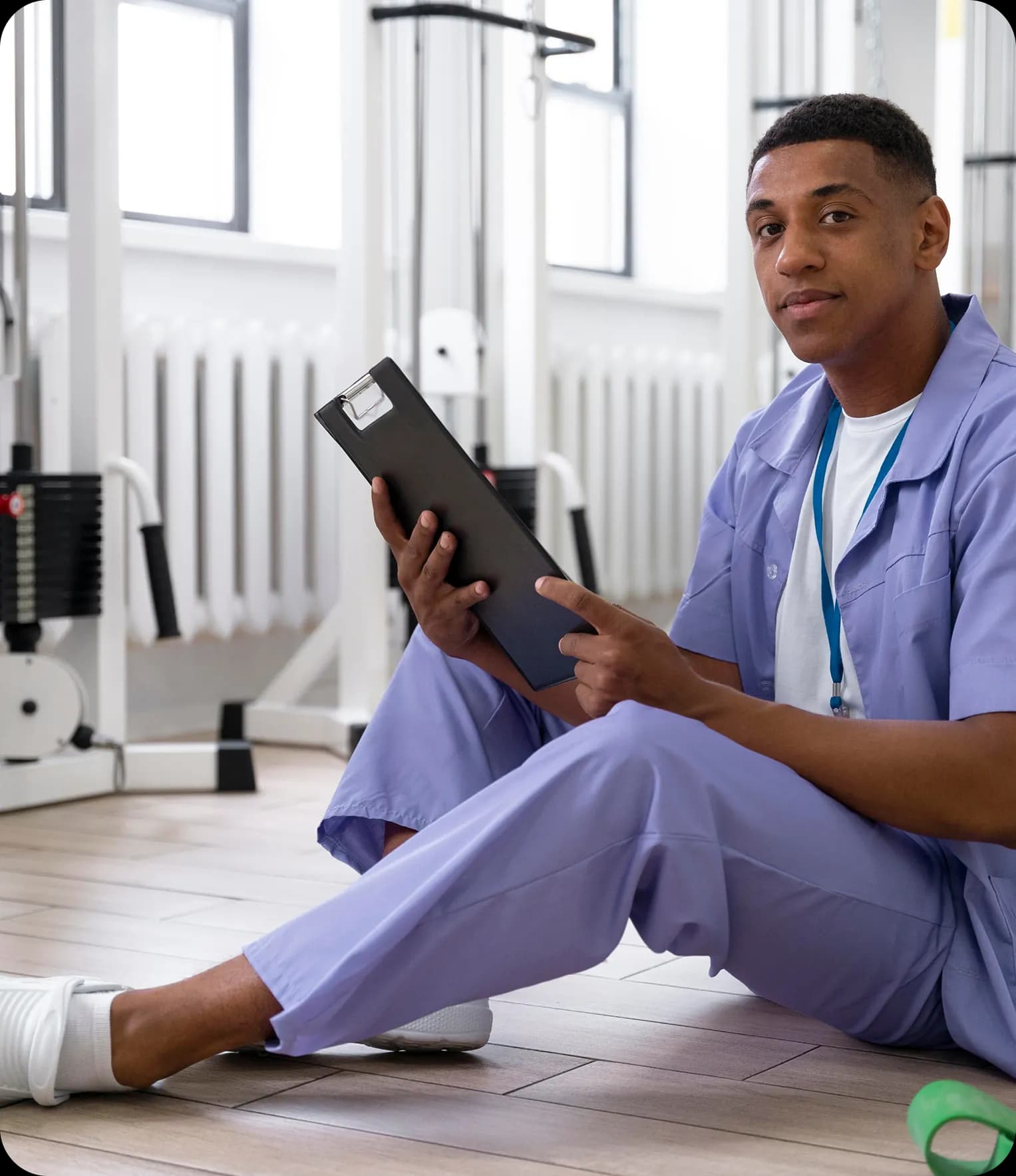 Physiotherapist sitting with clipboard in gym